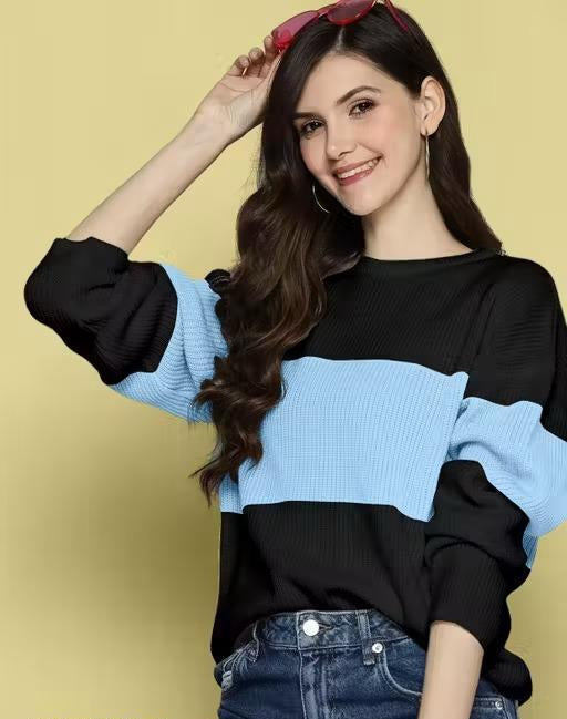 Woman wearing a black and blue sweater with a yellow background