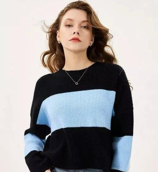 Woman wearing a black and blue striped sweater against a white background