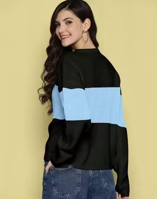 Woman wearing a black and blue sweater against a yellow background