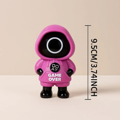 Toy figure Squid Game in a red hood with 'GAME OVER' text on a dark background