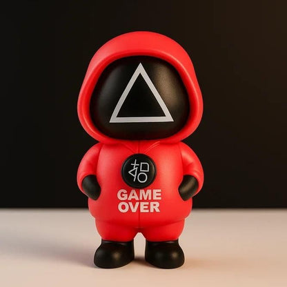 Toy figure in a red hood with 'GAME OVER' text on a dark background